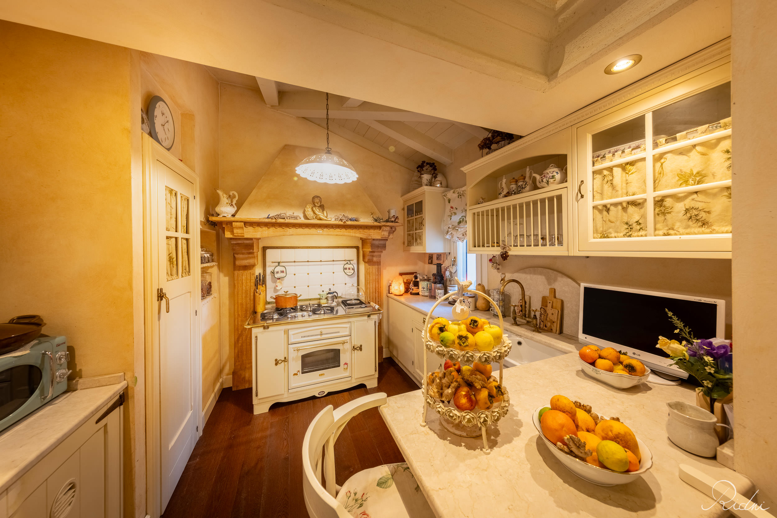 A cozy, rustic kitchen featuring a vintage stove and warm lighting, showcased through professional real estate photography.